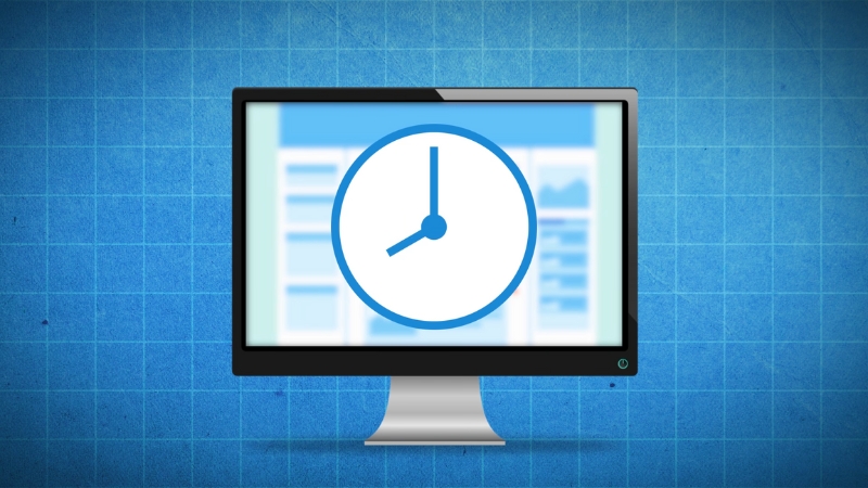 A Computer Monitor Displaying a Large Clock Icon on A Blue Grid Background