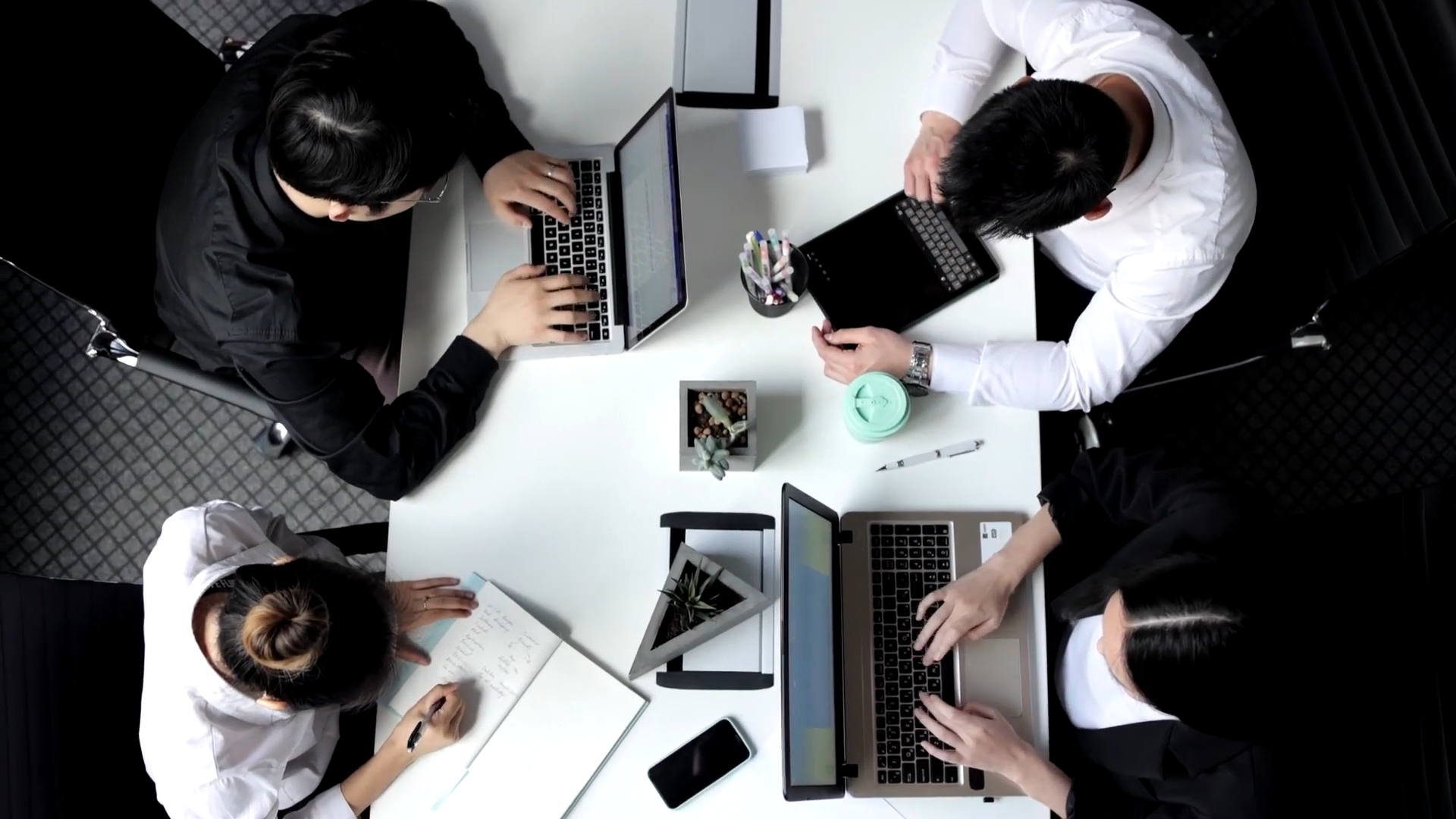 Team Working on Communications Planning at A Desk with Laptops