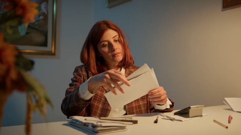 Woman opening an envelope at her desk
