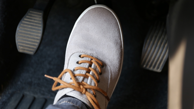 Foot pressing a car brake pedal showing everyday physics principles
