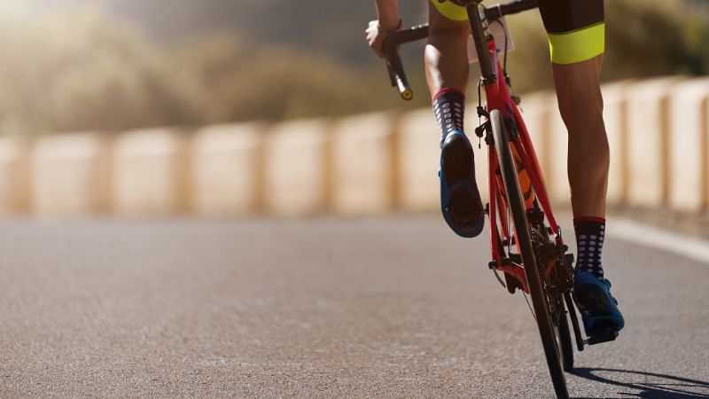 Cyclist riding on a road showing physics in sports and movement