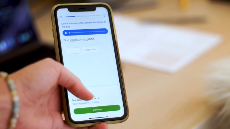 A person uses a language learning app on a smartphone to study Italian vocabulary
